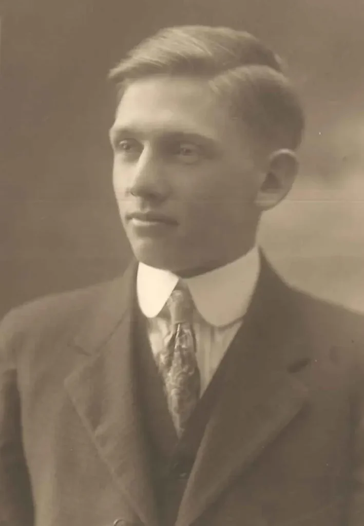 A vintage photo of a young man in a suit and tie, identified as Albert Kruger.