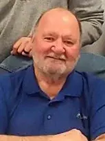 Mayor Roger Hartwigsen, a bearded man in a blue shirt, seated in a chair.