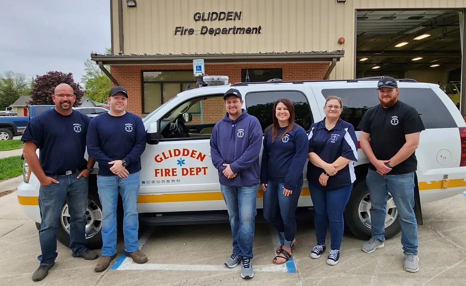 Glidden EMS in front of fire department building and vehicle.